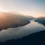 lake between trees and mountains